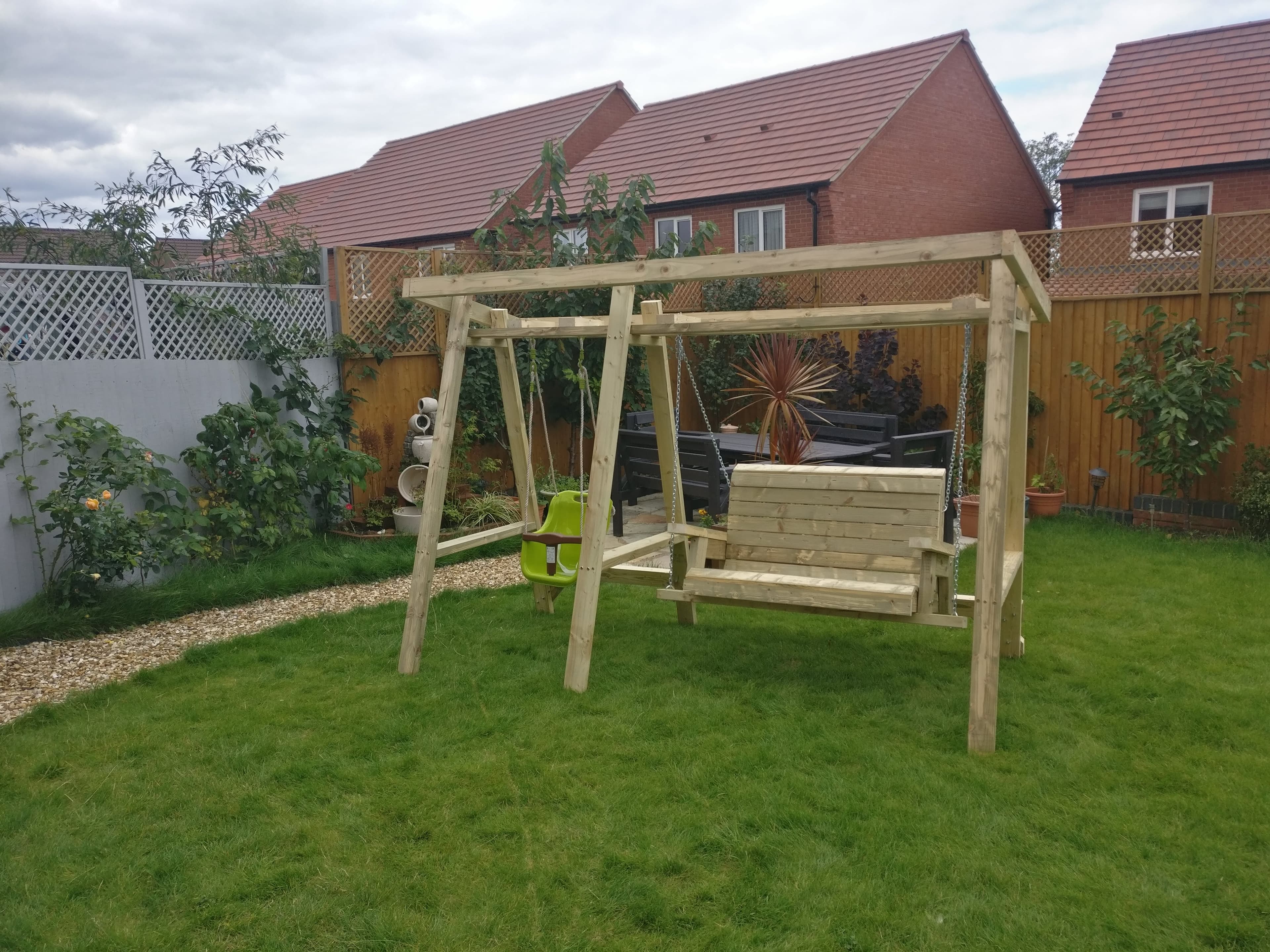 Finished garden swing set with bench swing and baby seat hung, styled in the garden