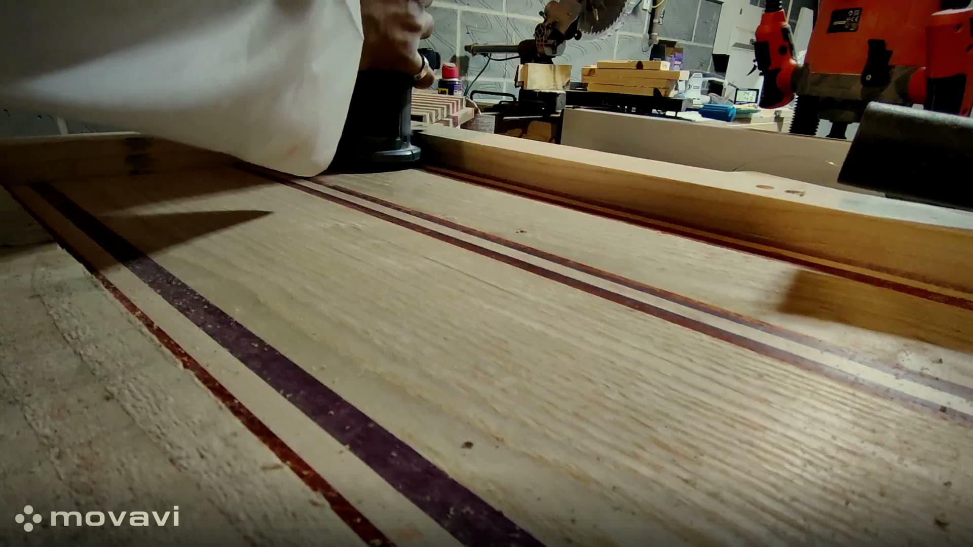 Hand-sanding a striped hardwood board in the workshop